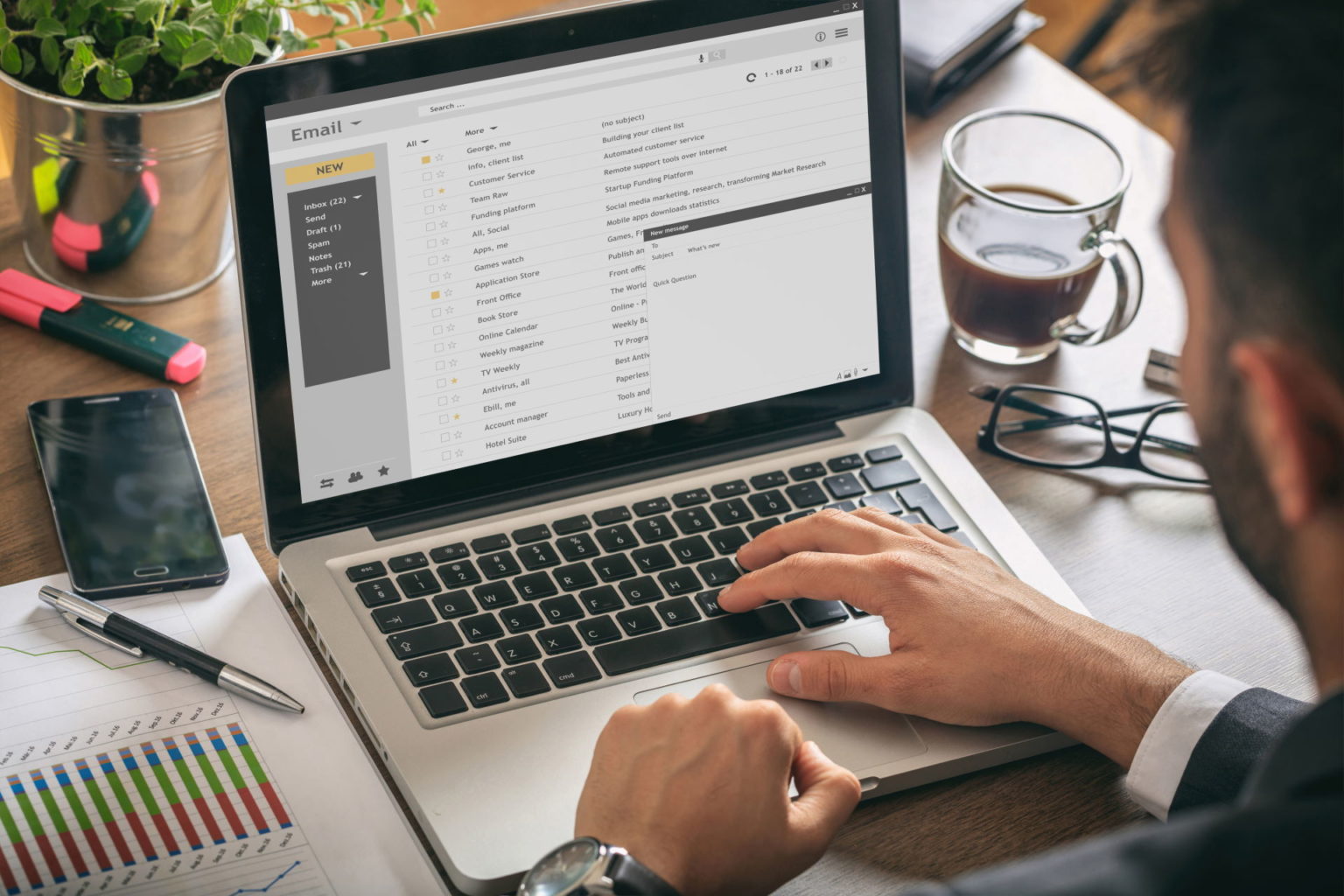 A man is using a laptop with an email on it.