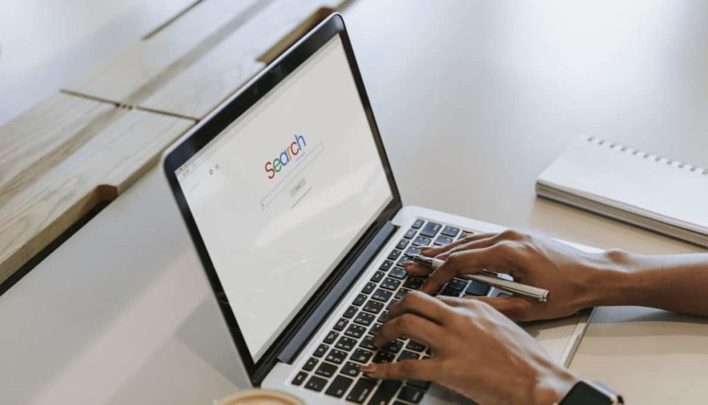 A person typing on a laptop with seo on the screen.