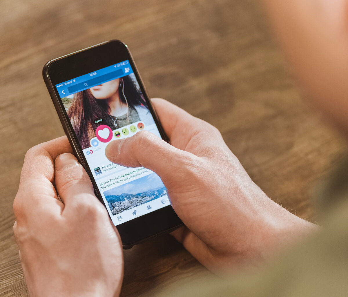 man using Facebook on smartphone