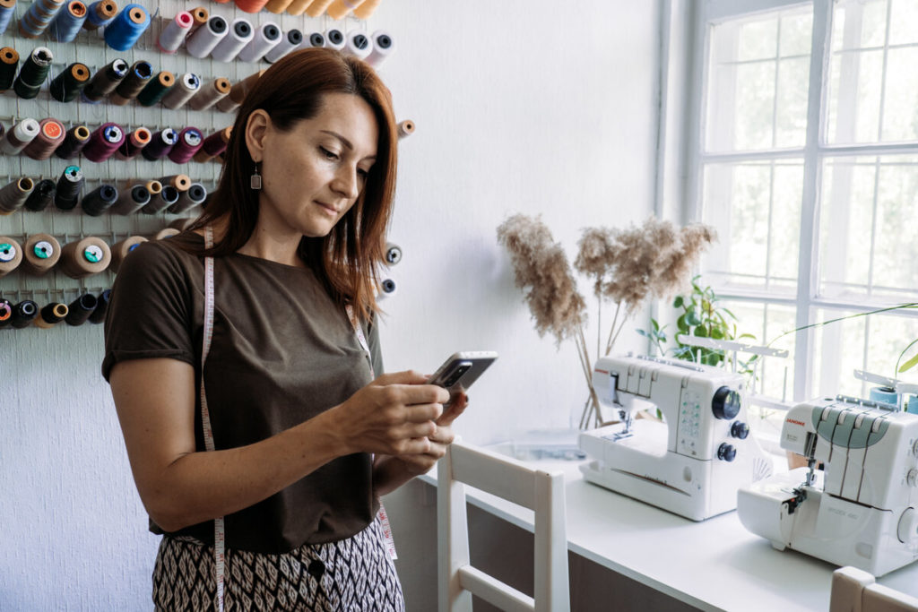 Support local business, small business. Run Own Sewing Business startup. Woman owner of the sewing business checking orders in home studio.