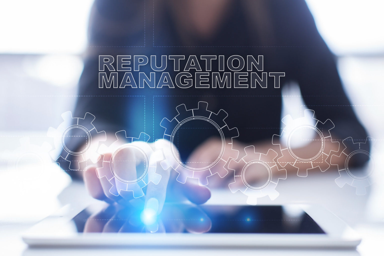 A woman is using a tablet with the word reputation management on it.