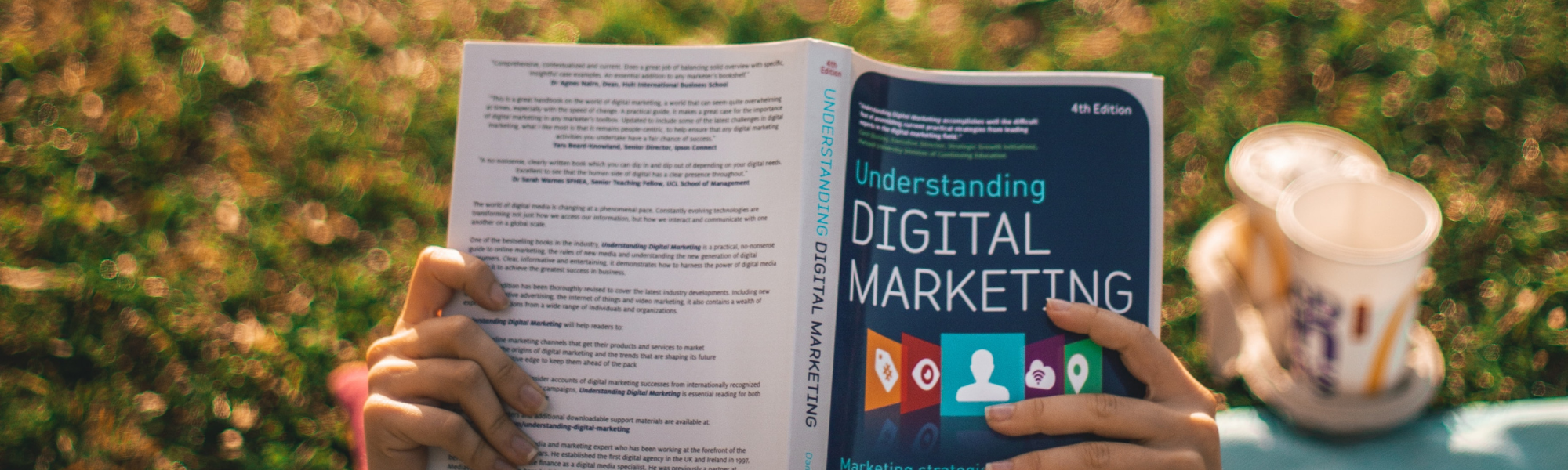 A person studying internet marketing through a book.