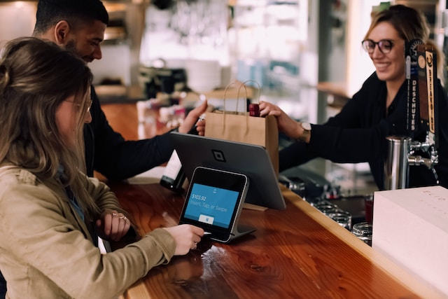 A group of people at a bar using a tablet.