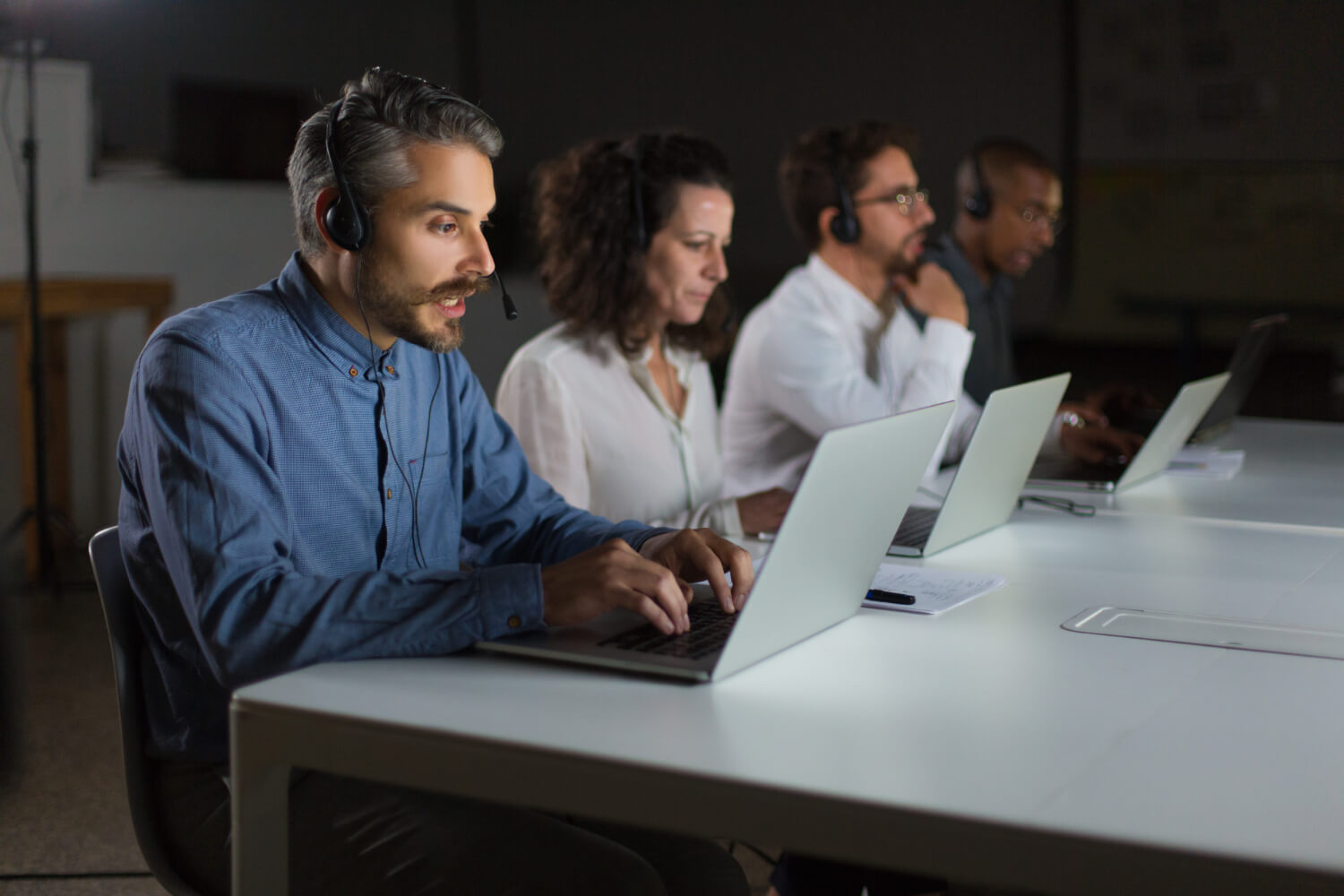 A group of people working on laptops in a conference room.