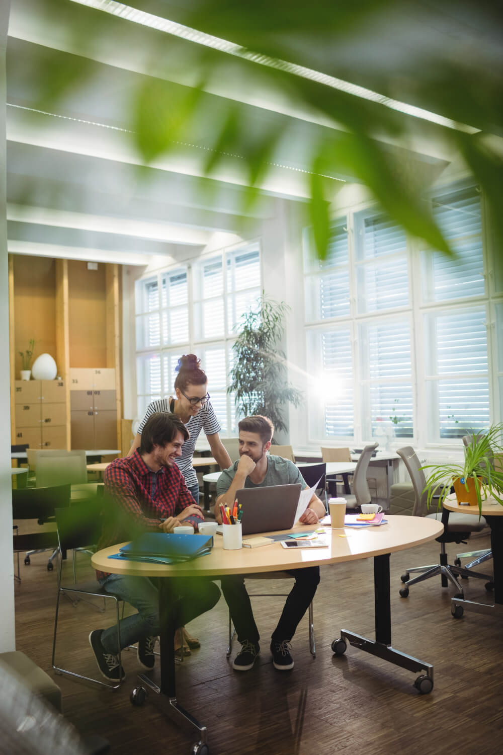 A group of people sitting around a table in an office.