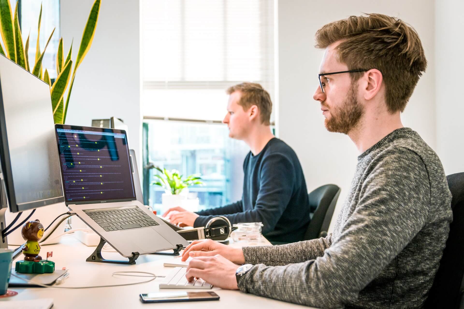 Two men working on computers in an office.