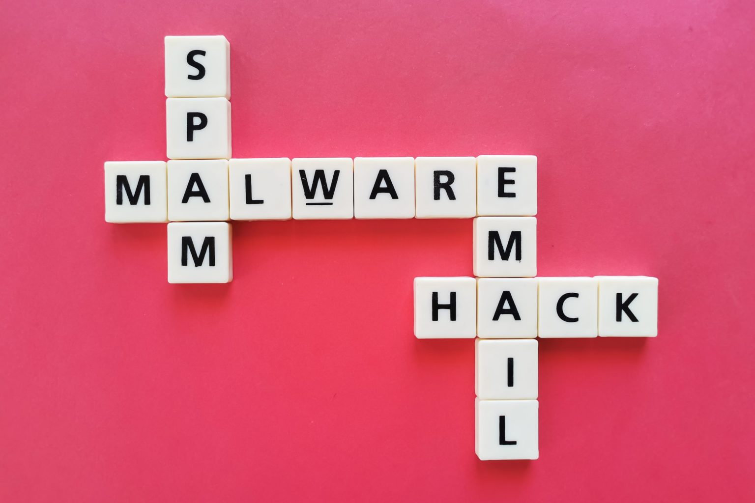 Crosswords malware, spam, email and hack against red background.